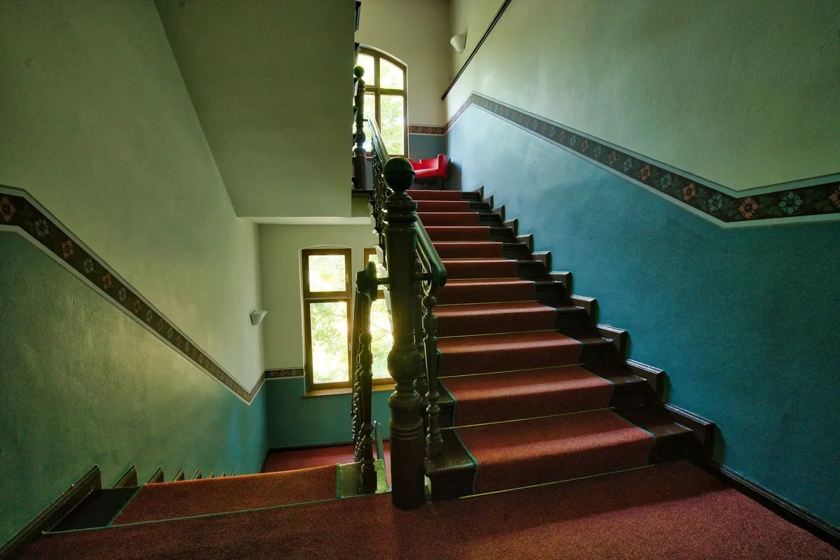 A stair flight rising to a half landing inside a stairwell.