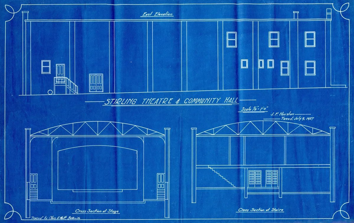A 1927 traced floor plan of a theatre on blueprint paper, with its walls and rooms drawn in white linework.