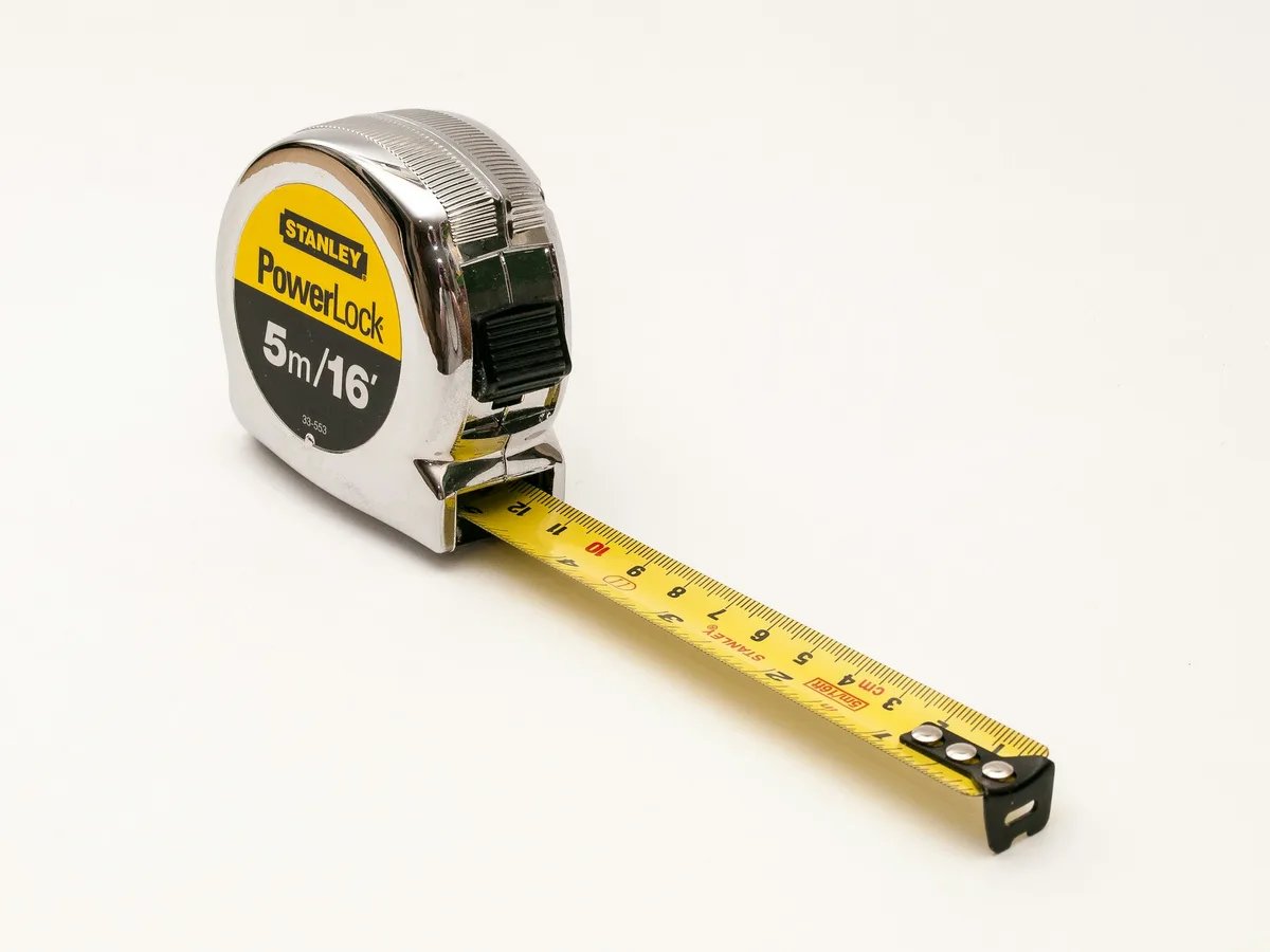 A tape measure extended on a white surface.