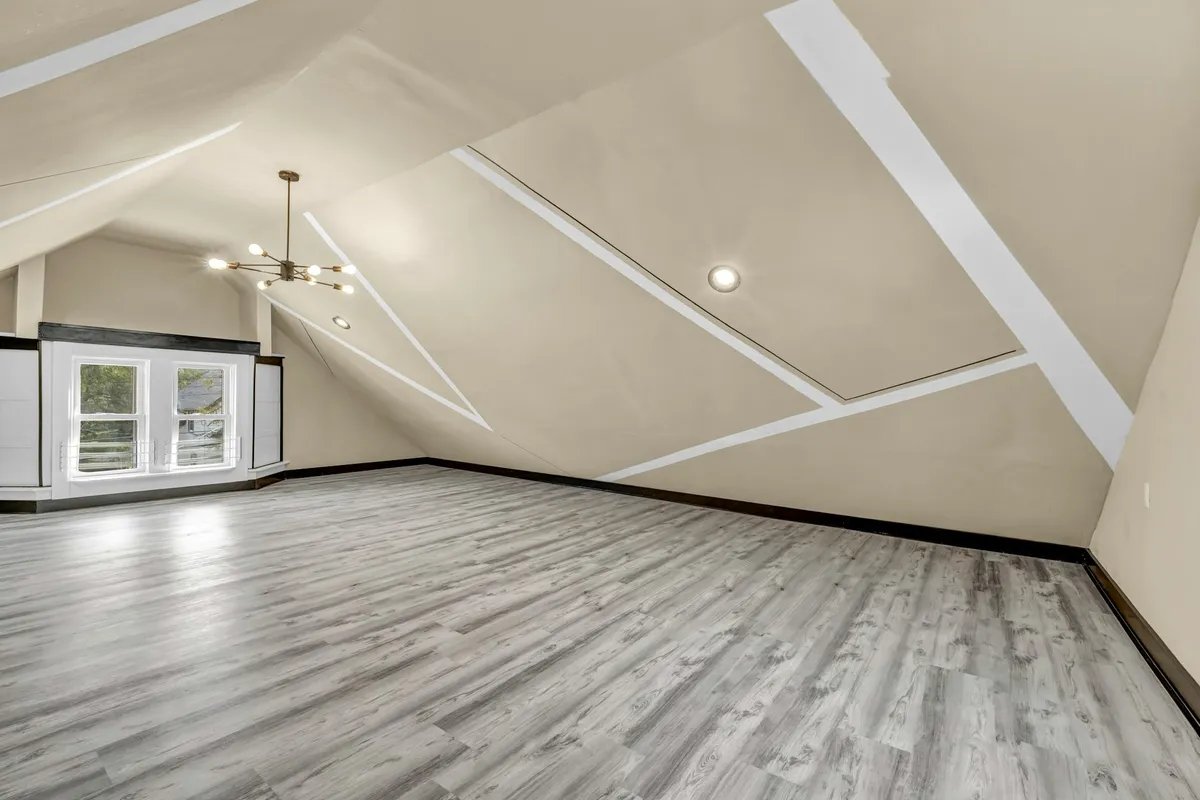 An empty attic room where the sloping ceiling comes down to meet the floor along one side.